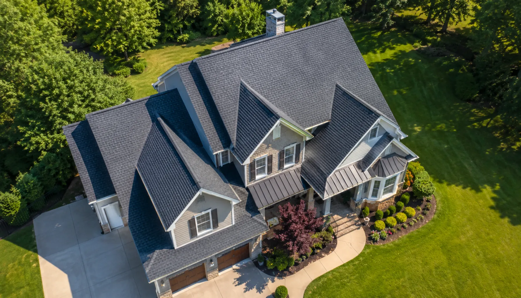 Residential roof replacement in progress with a worker installing new asphalt shingles on a suburban American home